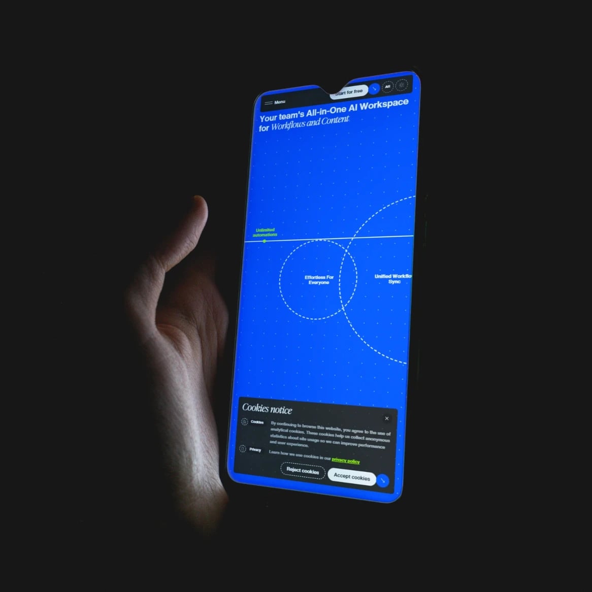 Billix website: Hand holding a phone in the dark, its screen showing the Billix mobile site: 'Your team's All-in-One AI Workspace for Workflows and Content'